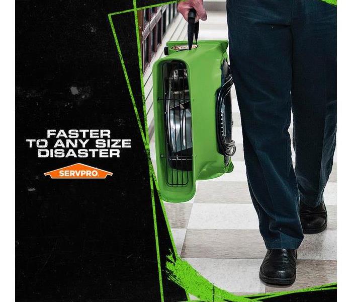 SERVPRO tech carrying water extraction tool with the caption: FASTER TO ANY SIZE DISASTER