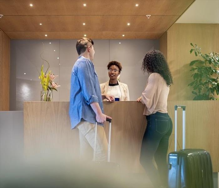 Man, woman and clerk at front desk of motel